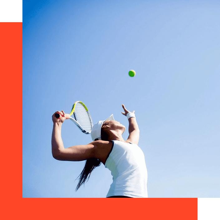 A woman swinging at a tennis ball with her racket.