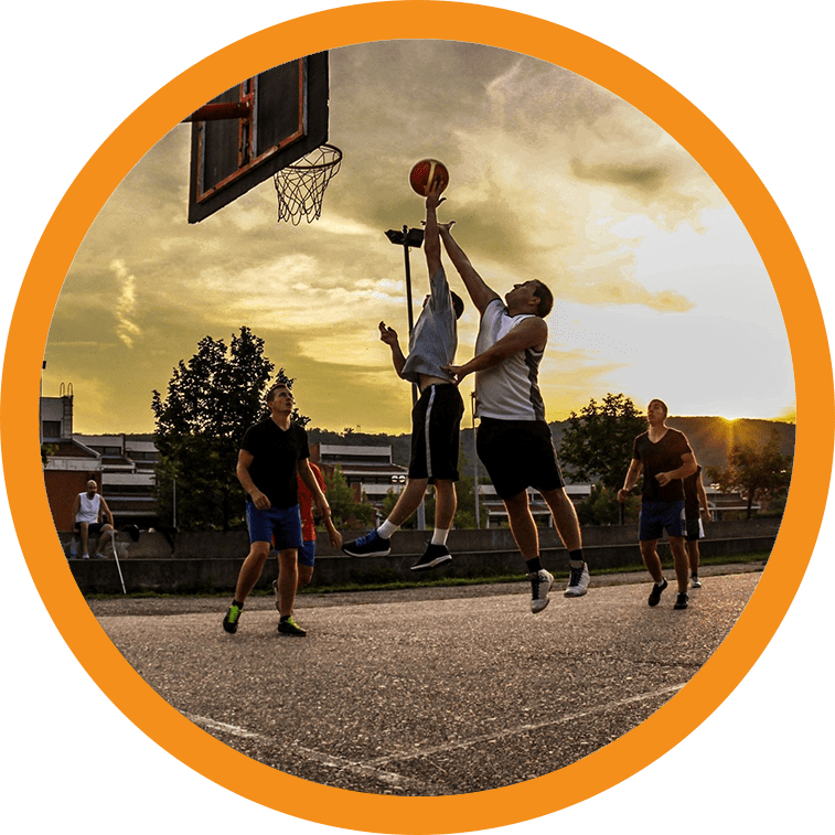 A group of men playing basketball on an outdoor court.