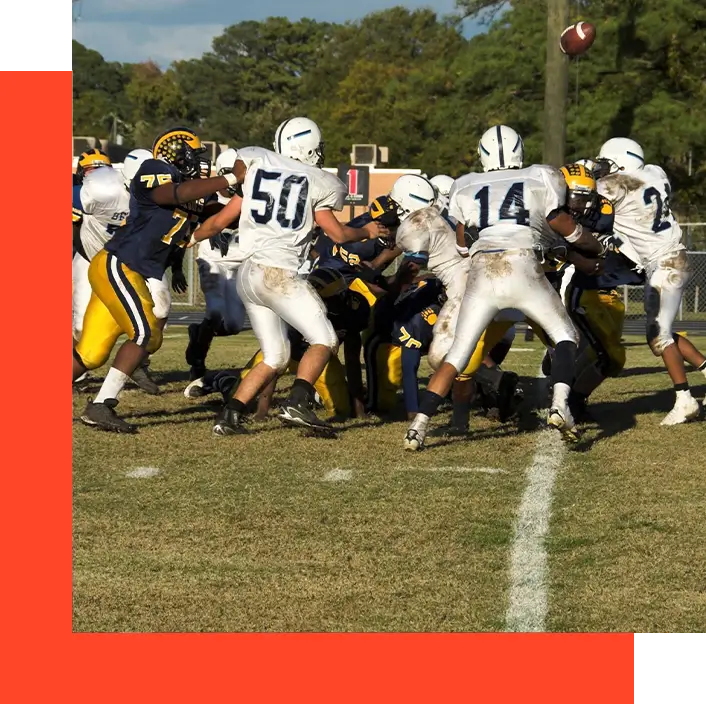 A group of football players are playing on the field.